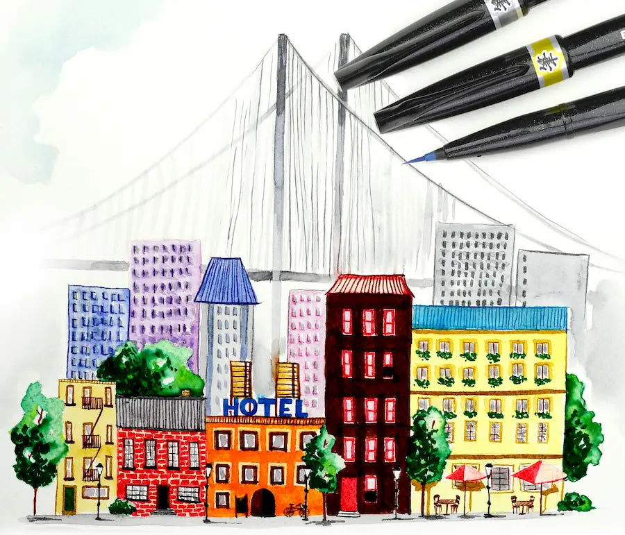 Colorful cityscape model with buildings and a hotel sign, surrounded drawn with Pentel Brush Sign Pen Artist by the brushes.