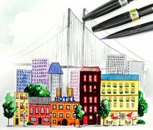 Colorful cityscape model with buildings and a hotel sign, surrounded drawn with Pentel Brush Sign Pen Artist by the brushes.